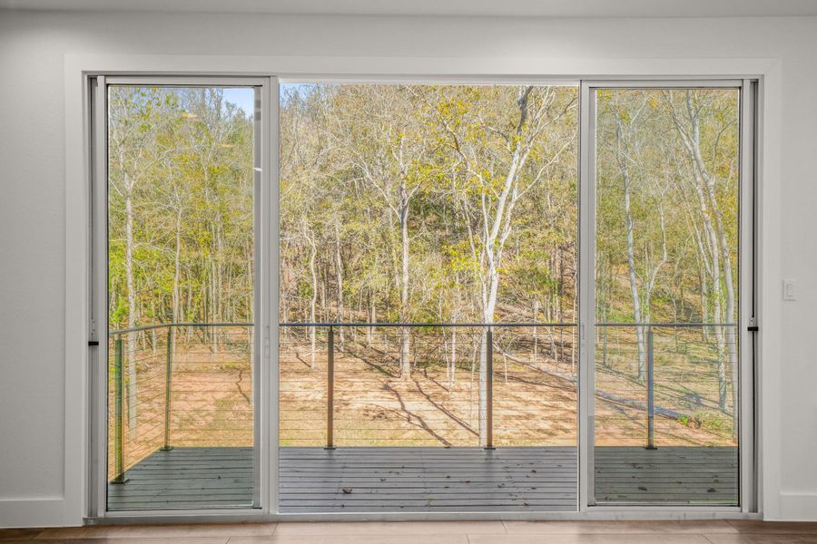 Doorway with view of scattered trees and baseboards