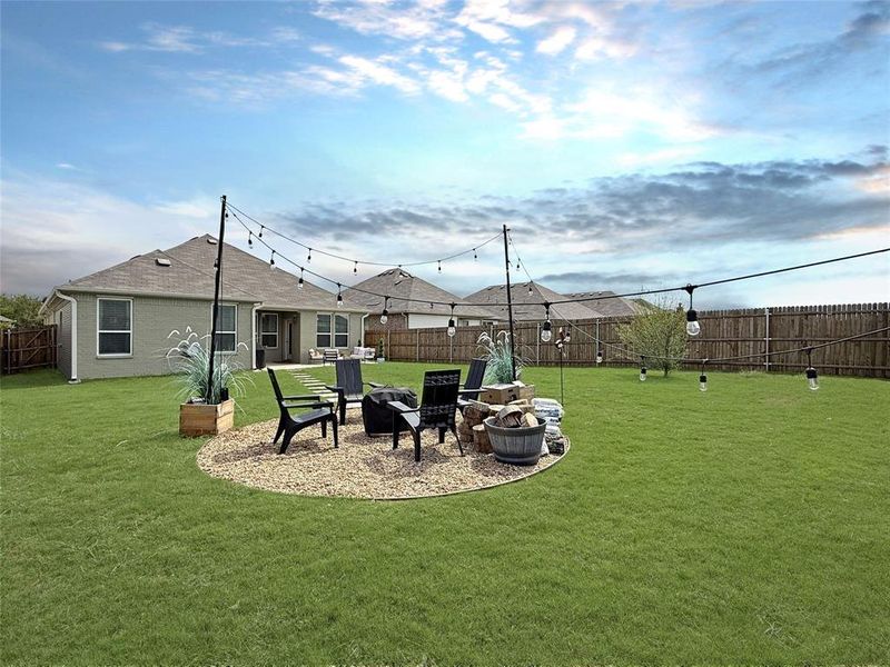 Fenced backyard featuring a patio and an outdoor fire pit Fenced backyard featuring a patio and an outdoor fire pit