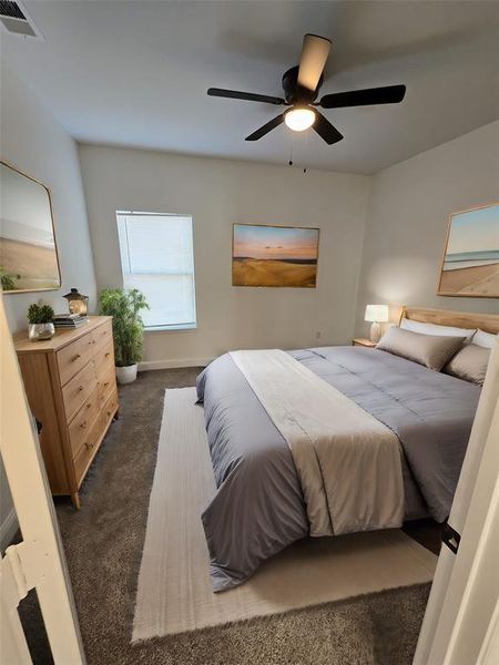 Bedroom with ceiling fan and dark carpet