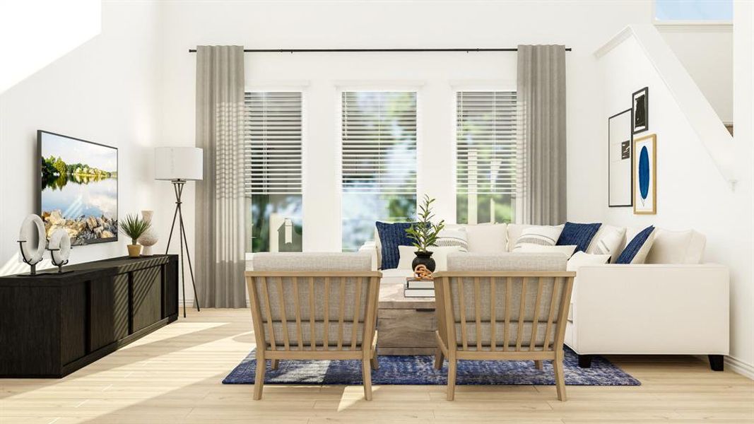 Living room with light hardwood / wood-style flooring and a high ceiling