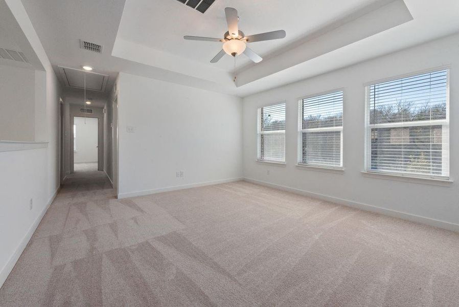 Carpeted spare room with attic access, a raised ceiling, ceiling fan, and recessed lighting Carpeted spare room with attic access, a raised ceiling, ceiling fan, and recessed lighting
