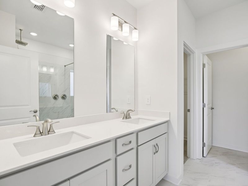 The primary bathroom offers dual vanity sinks and a walk-in shower. The primary bathroom offers dual vanity sinks and a walk-in shower.
