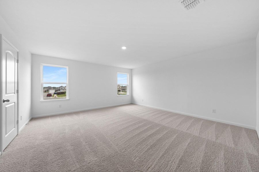 Empty room with light carpet, plenty of natural light, and recessed lighting