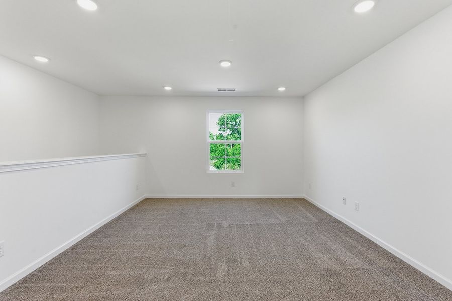 A room with a carpet and a window.
