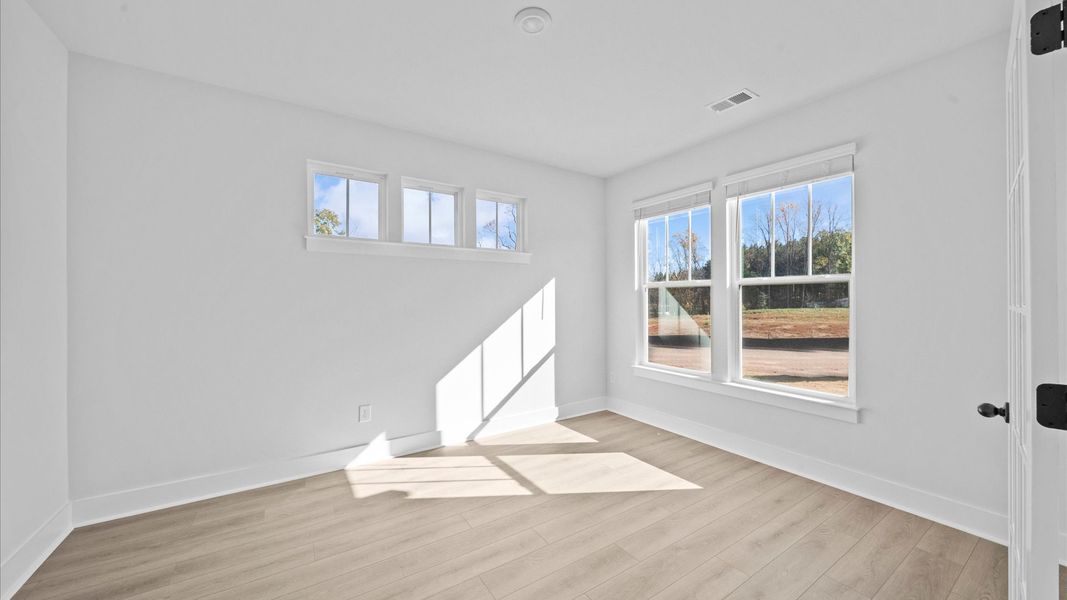 Vibrant natural light and tasteful design define this French door study near the front of the home