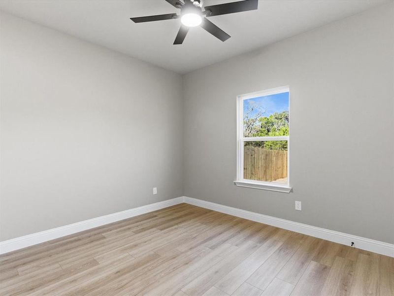 Spare room with light wood-style flooring and a ceiling fan Spare room with light wood-style flooring and a ceiling fan