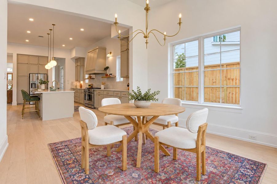 Sun-filled breakfast room surrounded by windows and natural light, creating an inviting spot for morning coffee, casual meals, or weekend brunch. French Oak floors and statement lighting add warmth and sophistication, while the intimate setting flows effortlessly into the kitchen. Sun-filled breakfast room surrounded by windows and natural light, creating an inviting spot for morning coffee, casual meals, or weekend brunch. French Oak floors and statement lighting add warmth and sophistication, while the intimate setting flows effortlessly into the kitchen.