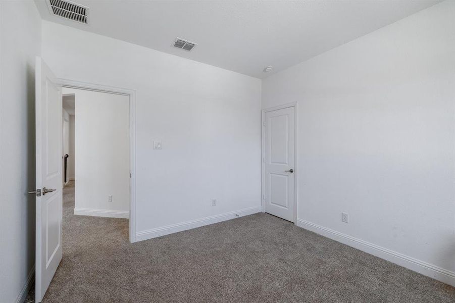 Spare room with carpet, visible vents, and baseboards