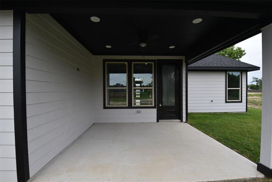 The covered back patio has a ceiling fan, making it more comfortable and inviting for outdoor relaxation.