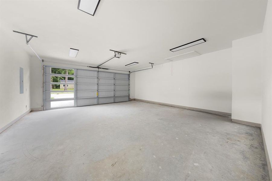 Garage featuring baseboards and a garage door opener