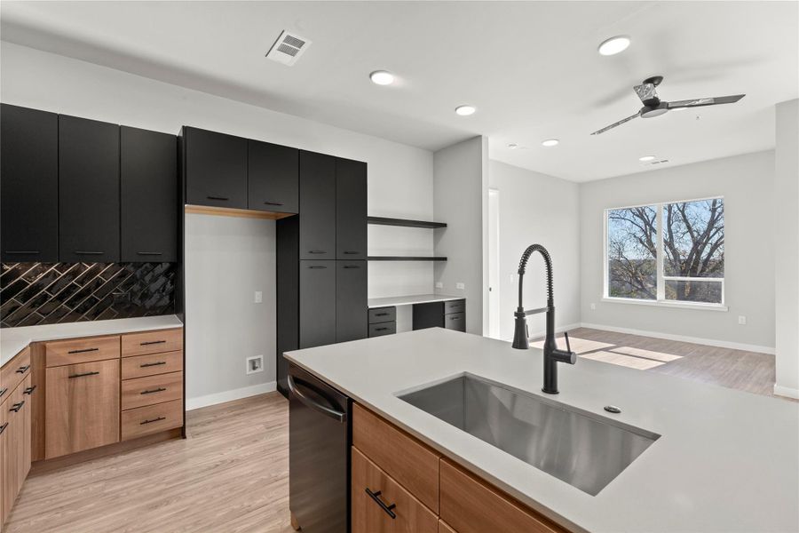 Kitchen with dishwashing machine, sink, ceiling fan, and light wood-type flooring