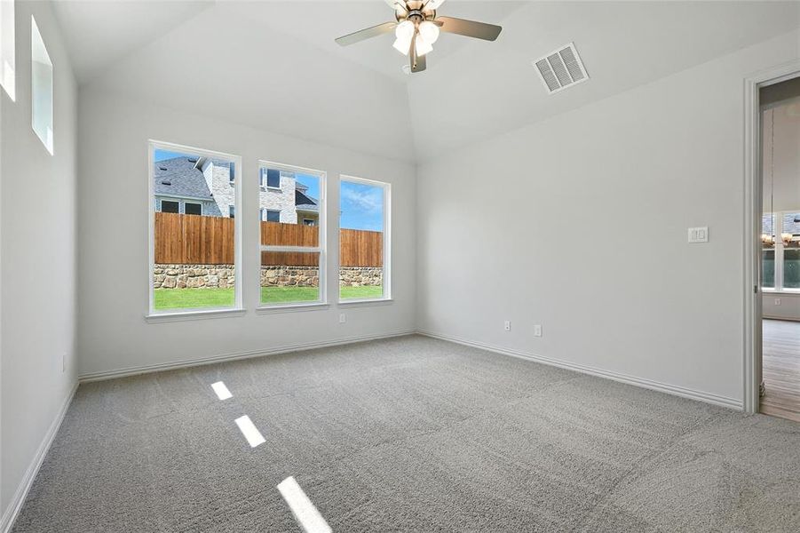 Spare room featuring carpet floors, ceiling fan, and vaulted ceiling Spare room featuring carpet floors, ceiling fan, and vaulted ceiling