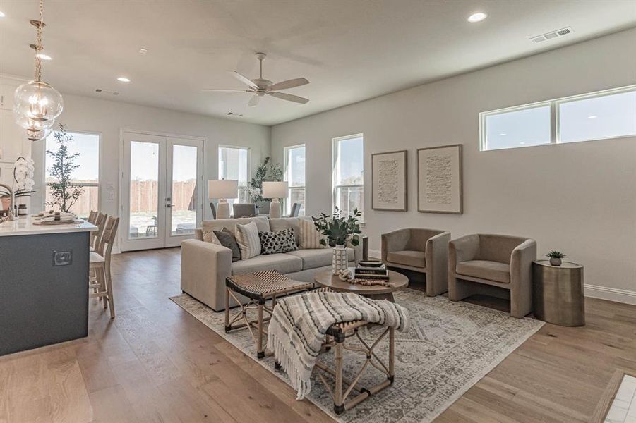 Living room featuring wood-type flooring, ceiling fan, and french doors