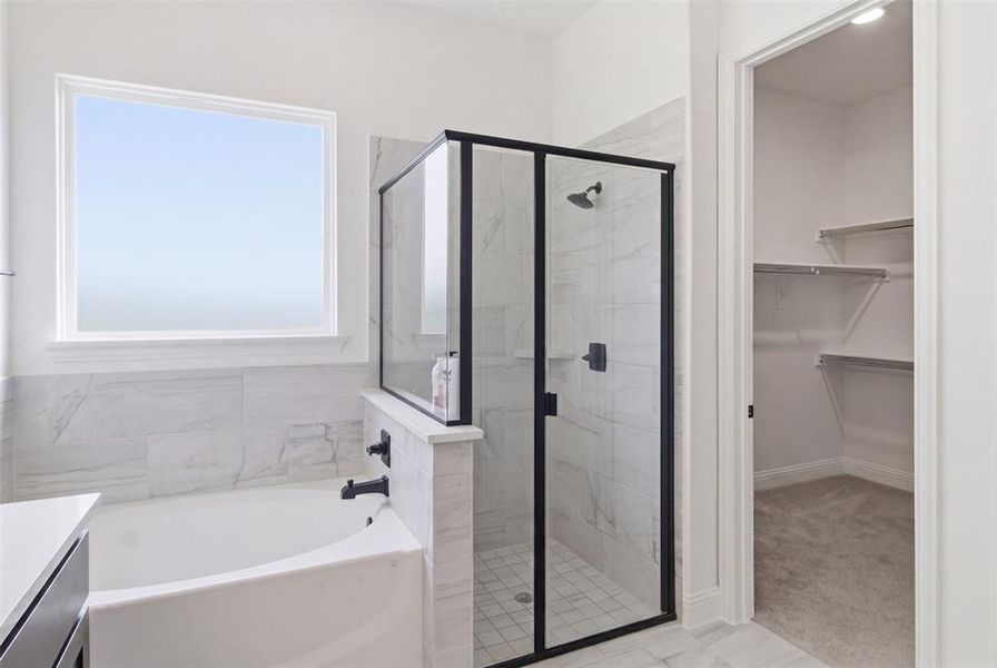 Bathroom featuring a built-in tub with matte black fixtures, a walk-in shower with clear glass and black-framed enclosure, and light-toned tile flooring and wall surrounds