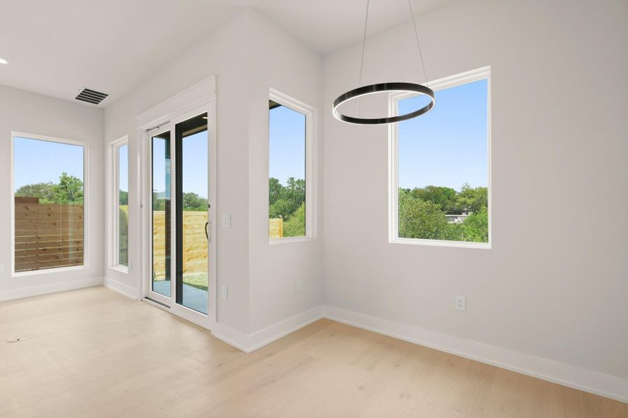 Unfurnished dining area with baseboards and light wood-style flooring Unfurnished dining area with baseboards and light wood-style flooring