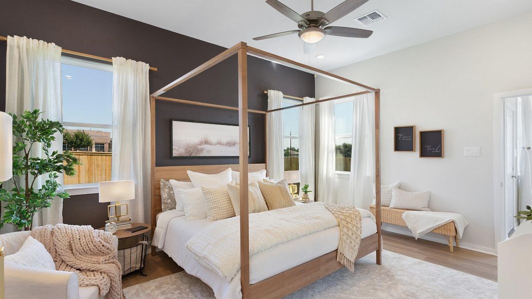 Natural light floods this primary bedroom featuring a vaulted ceiling and a classic four-poster bed frame. Natural light floods this primary bedroom featuring a vaulted ceiling and a classic four-poster bed frame.
