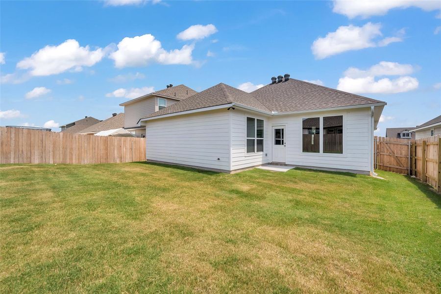 Back of property with a shingled roof, a fenced backyard, and a patio Back of property with a shingled roof, a fenced backyard, and a patio