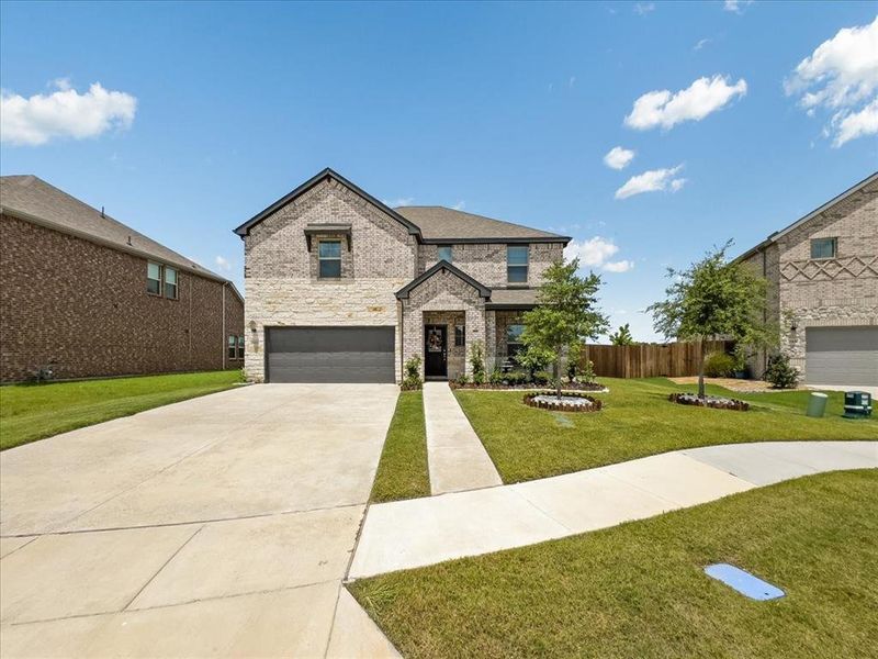 View of front of property featuring a garage and a front lawn