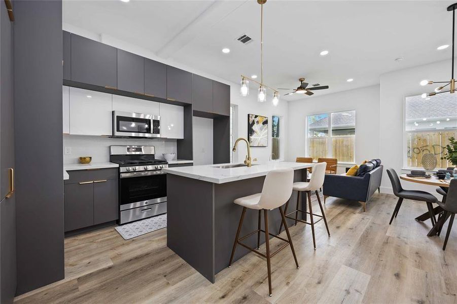 Stainless steel appliances, dual toned cabinets, and recessed lighting add to the modern feel of the home. Oversized windows bring in ample natural light. Finishes may vary from unit to unit.