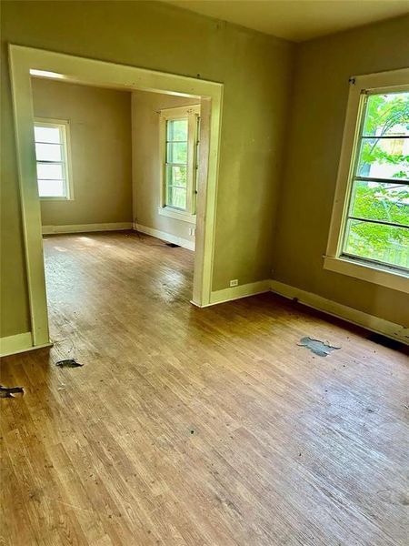Unfurnished room featuring plenty of natural light and wood finished floors Unfurnished room featuring plenty of natural light and wood finished floors
