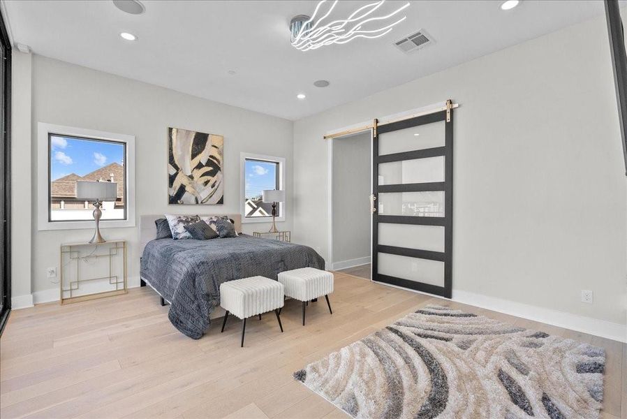 The primary bedroom offers its own private balcony, a stunning stone-accented fireplace, and unique designer lighting that creates a warm, luxurious ambiance. The primary bedroom offers its own private balcony, a stunning stone-accented fireplace, and unique designer lighting that creates a warm, luxurious ambiance.