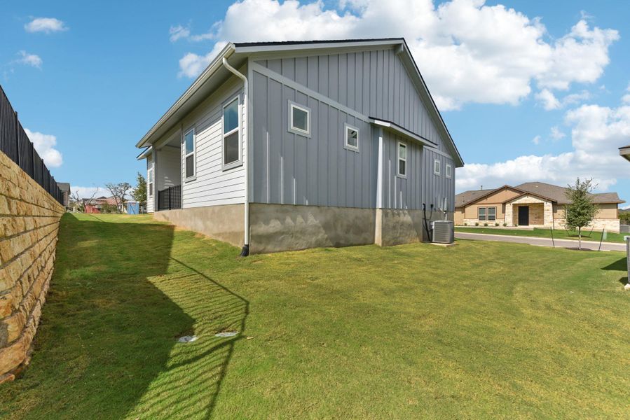View of side of home featuring a lawn and board and batten siding