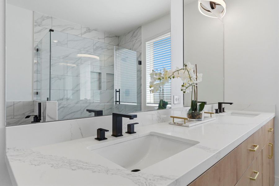 Spa-like primary bathroom featuring double sinks, a soaking tub, and a separate shower for a luxurious daily experience.