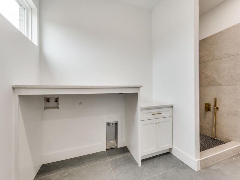 Laundry area featuring washer hookup and light tile patterned floors