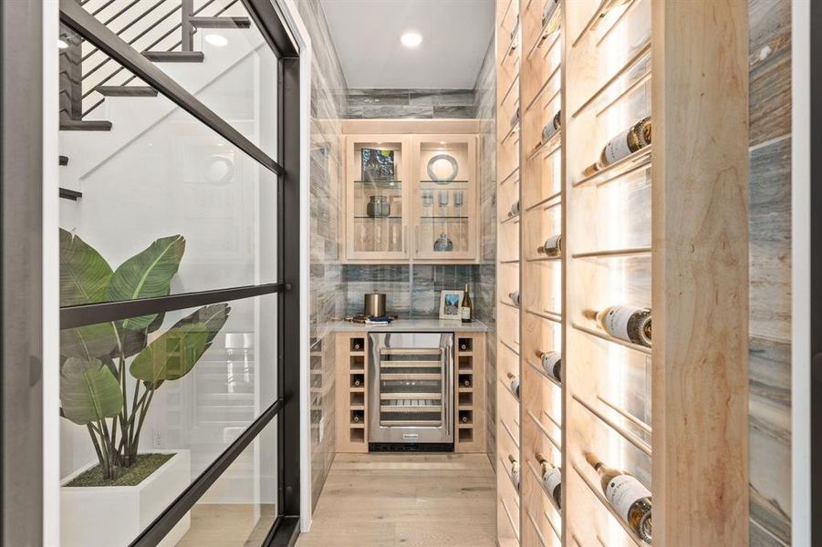 Wine cellar with wine cooler and light wood-type flooring Wine cellar with wine cooler and light wood-type flooring