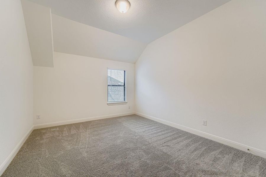 Bonus room with vaulted ceiling, carpet, and a textured ceiling Bonus room with vaulted ceiling, carpet, and a textured ceiling