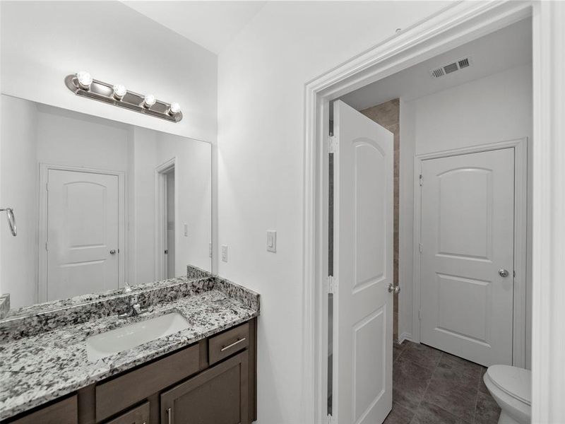 Bathroom with vanity, toilet, and tile patterned flooring