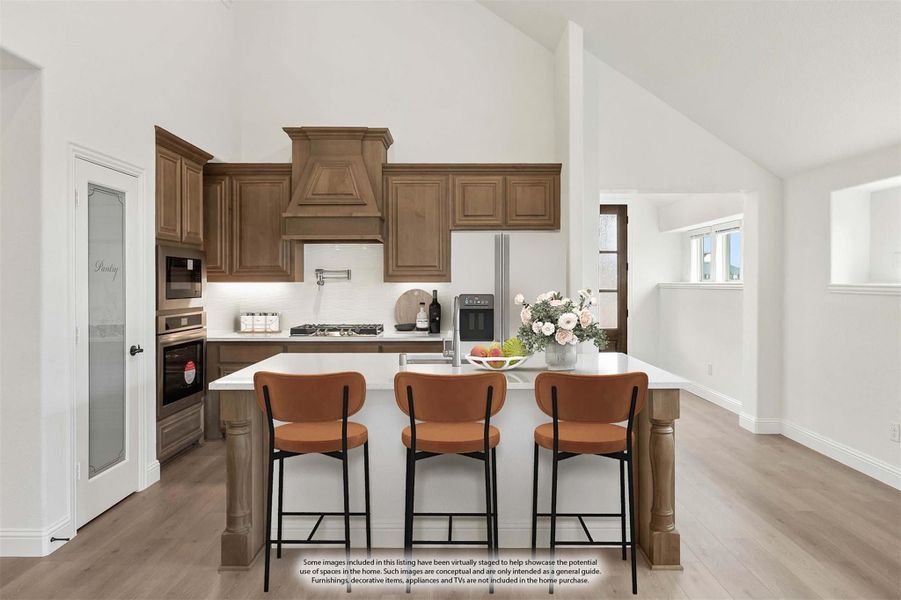 Kitchen with wood cabinets, decorative range hood, center island, and three bar stools on light hardwood floors Kitchen with wood cabinets, decorative range hood, center island, and three bar stools on light hardwood floors