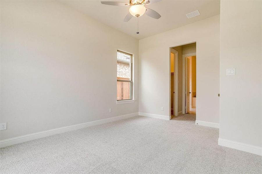 Carpeted spare room with ceiling fan