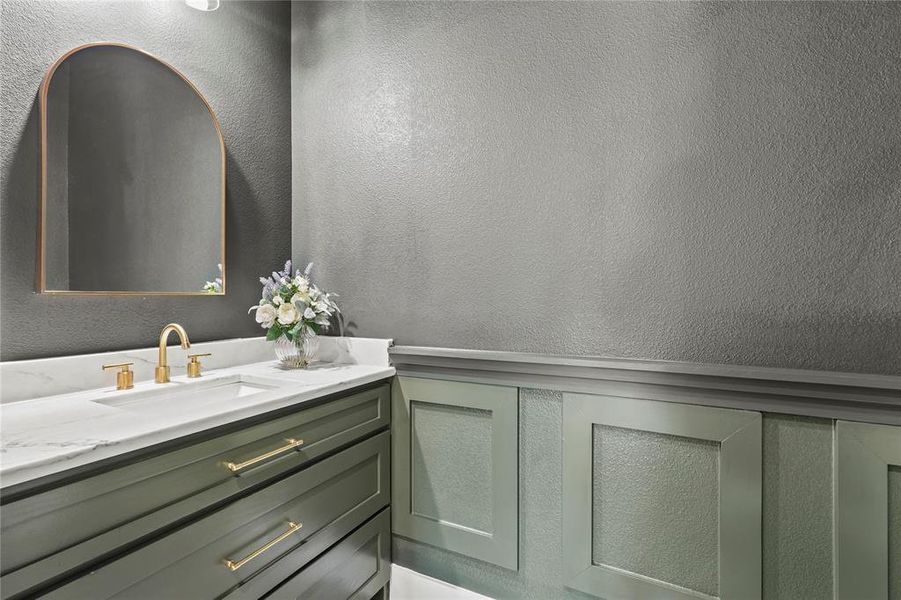 Bathroom featuring vanity and a textured wall Bathroom featuring vanity and a textured wall