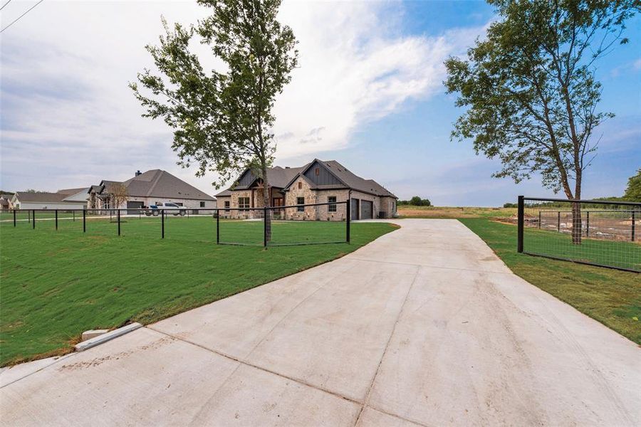 View of front facade featuring driveway and stone siding View of front facade featuring driveway and stone siding