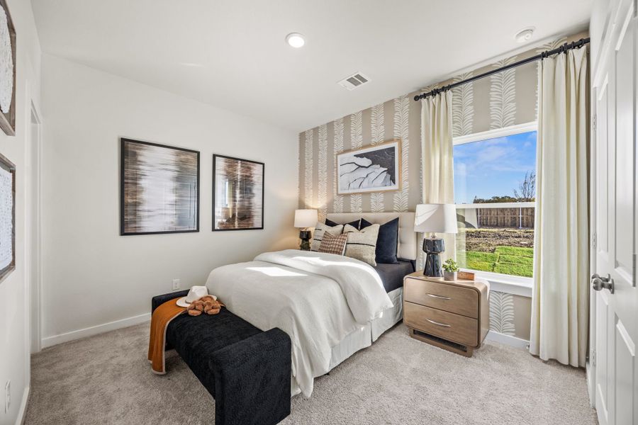 A bedroom with a large window. A bedroom with a large window.