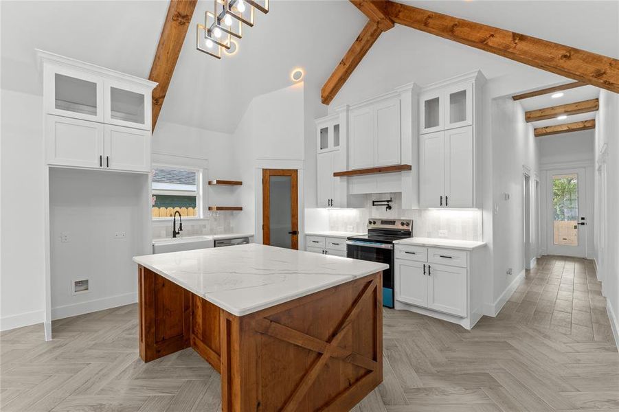 Kitchen featuring a wealth of natural light, a center island, appliances with stainless steel finishes, and white cabinets