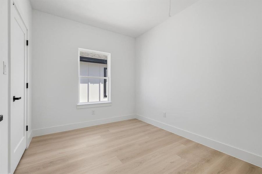 Spare room with light wood finished floors and baseboards Spare room with light wood finished floors and baseboards