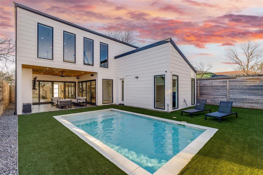 Backyard featuring a heated saltwater pool, a turf lawn, outdoor lounge area, a fenced backyard