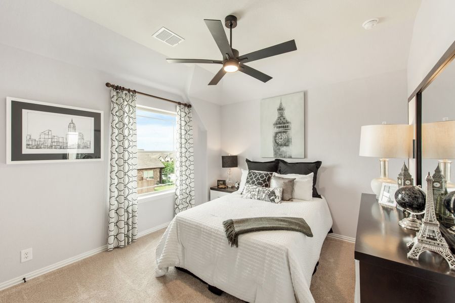 Bedroom with ceiling fan, carpet flooring, large window with patterned curtains, and black and white decor