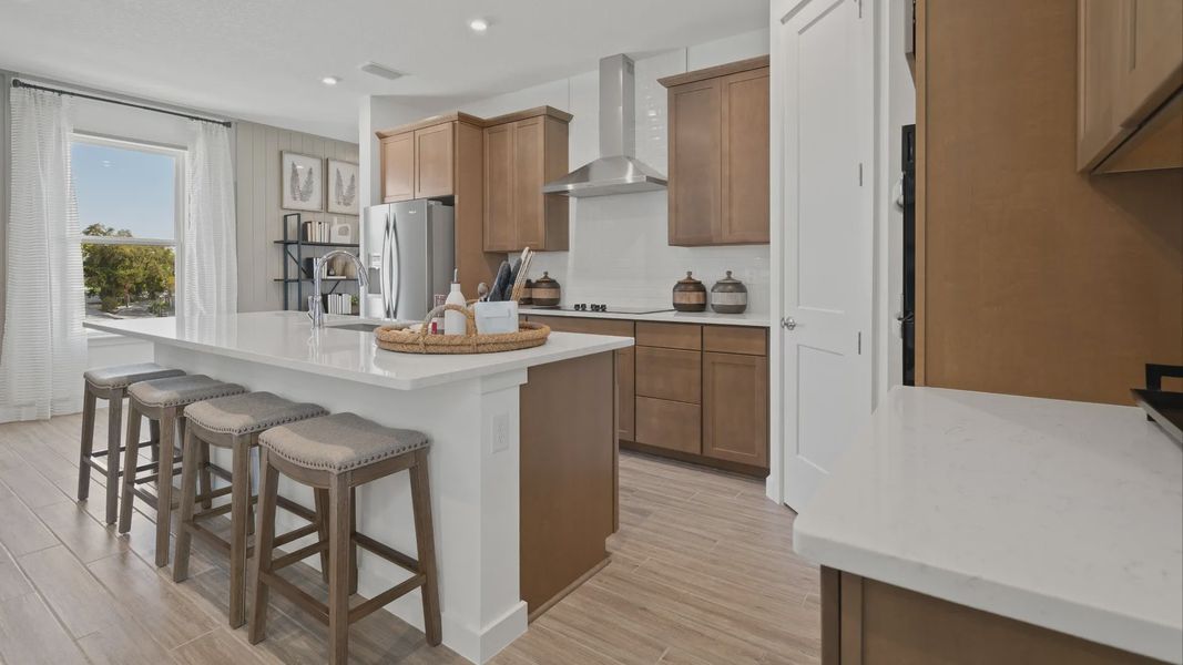 Kitchen with large island and large window in a DRB Home Clementine model at the Trinity Place community.