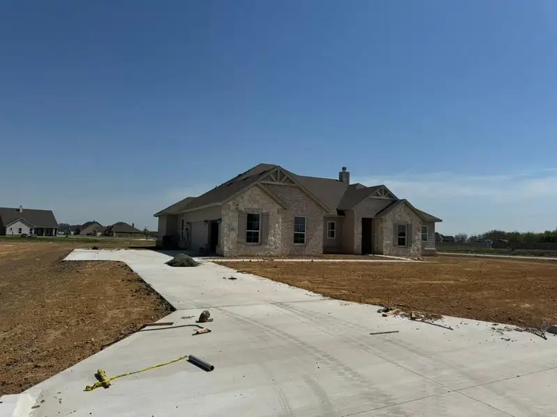 Craftsman house with a chimney, stone siding, a garage, and concrete driveway