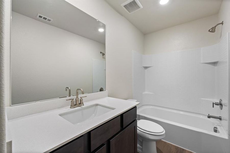 Full bathroom featuring wood-type flooring, toilet, vanity, and bathtub / shower combination