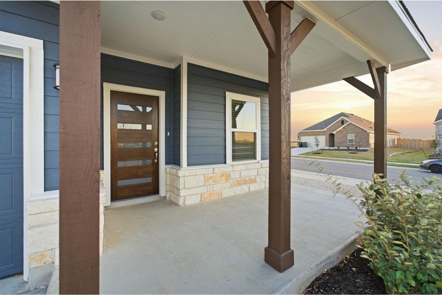 View of exterior entry with a porch and stone siding
