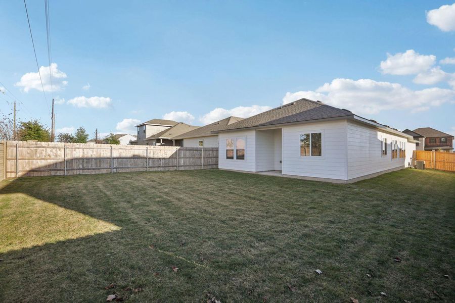 Rear view of house featuring a fenced backyard and a patio area