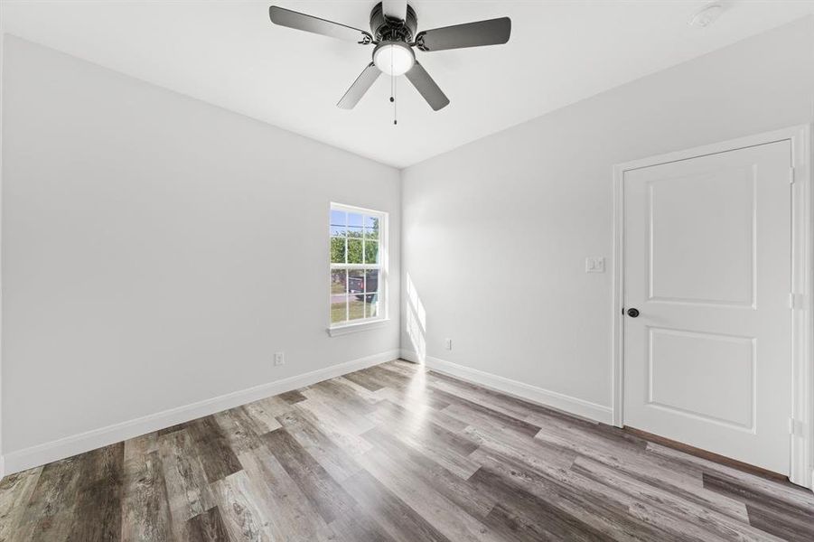 Spare room featuring wood finished floors and a ceiling fan Spare room featuring wood finished floors and a ceiling fan