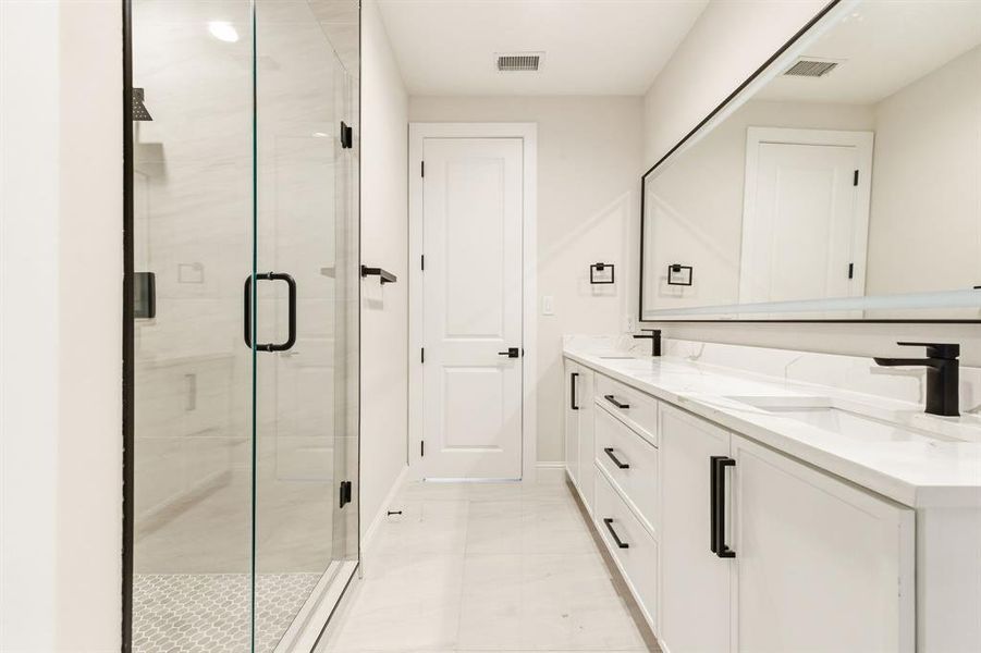Bathroom with double vanity and a stall shower