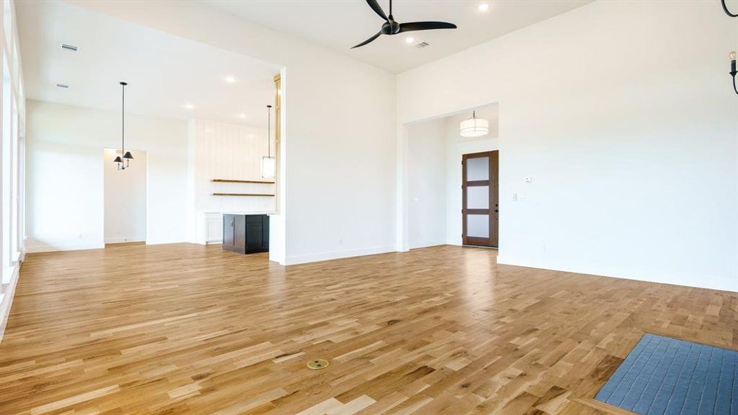 Unfurnished living room with ceiling fan and light wood-type flooring