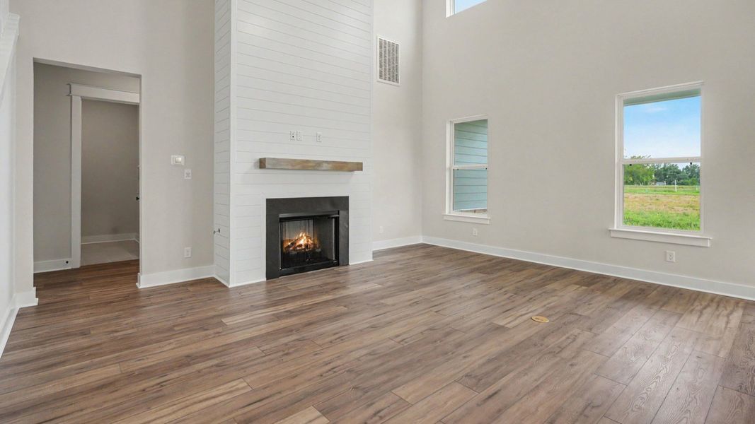 Gathering room with fireplace, high ceiling, and windows
