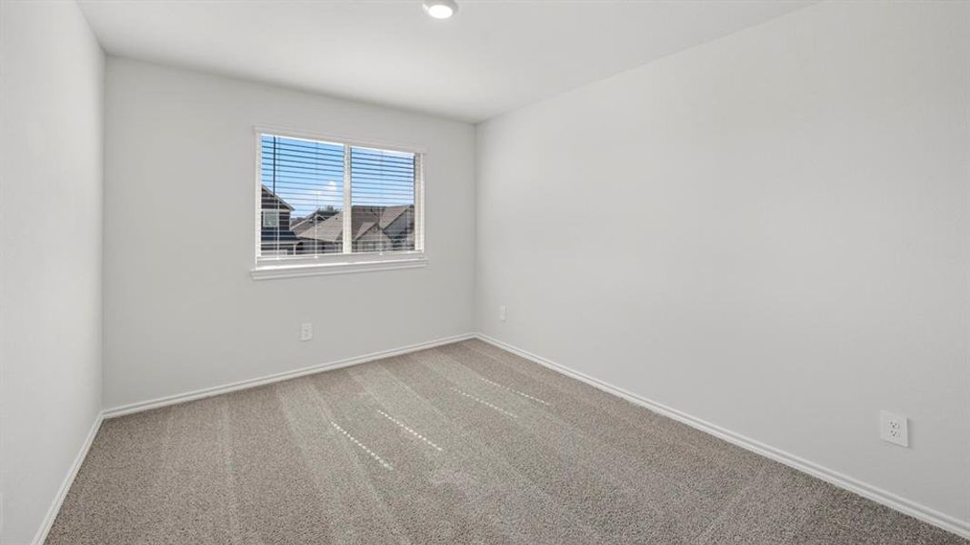 Spare room featuring carpet flooring and baseboards